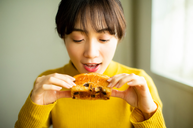 パンを食べるアラサー女性