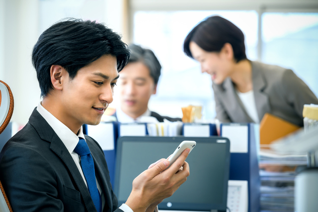 スマホでメッセージを送るサラリーマン